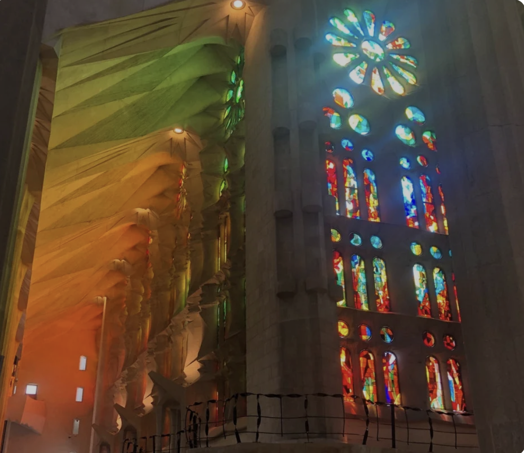 Stained glass windows of Sagrada Família casting colorful light patterns inside the cathedral